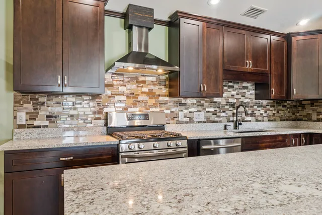 a kitchen with stainless steel appliances a sink stove and cabinets
