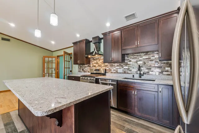 a kitchen with kitchen island a sink stove and refrigerator