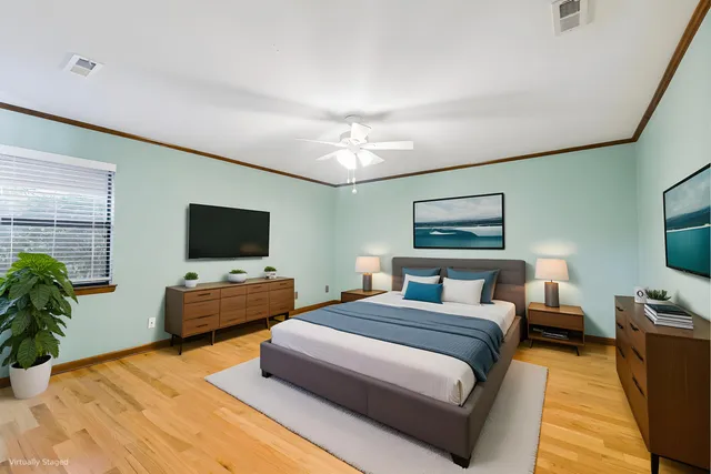 a bedroom with a bed a couch and a flat screen tv