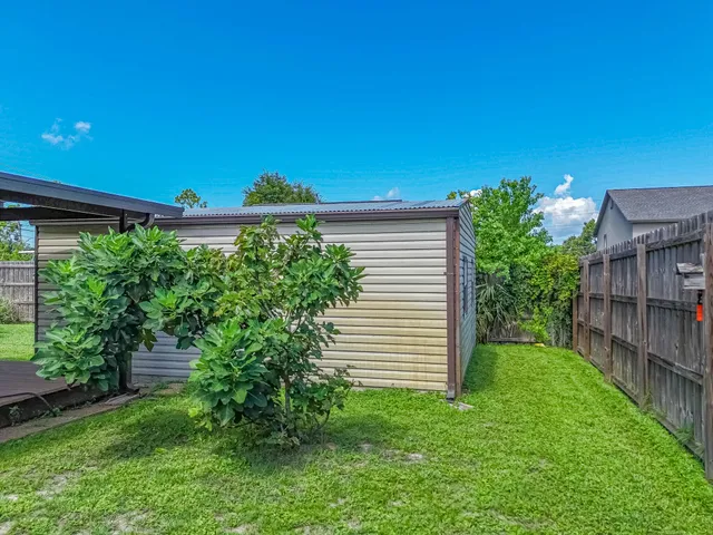 a backyard of a house with plants and wooden fence