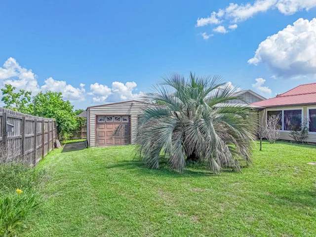 a view of a house with a big yard and potted plants