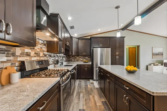 a kitchen with a sink a counter space stainless steel appliances and cabinets