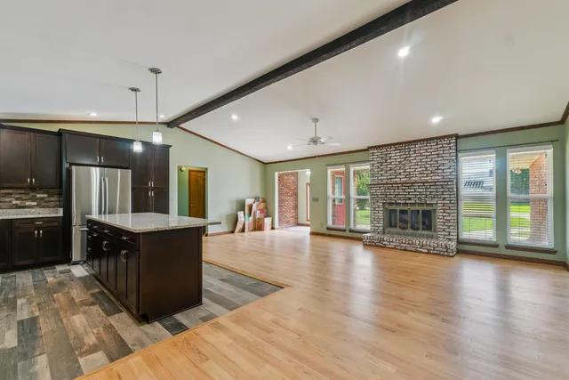 a large kitchen with granite countertop a large counter top and stainless steel appliances