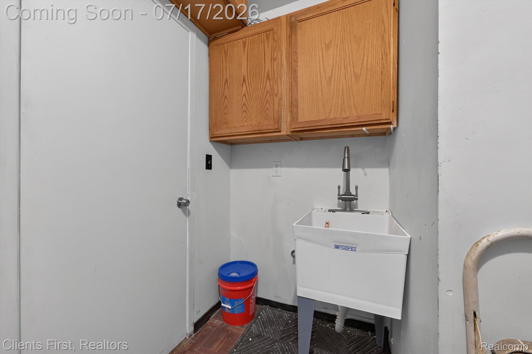 36852 Chase Street Romulus, MI 48174 - Photo 28 of 40 Utility sink with a chrome faucet, accompanied by wood-finish wall cabinetry