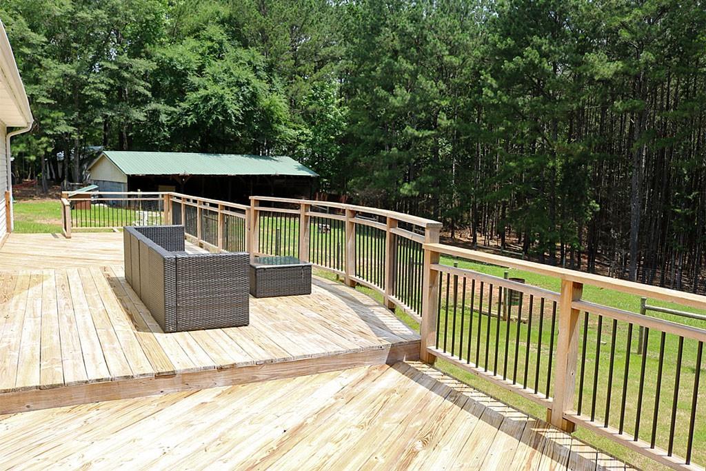 3129 Etchison Road Loganville, GA 30052 - Photo 29 of 58 a view of a deck with two chair and a floor to ceiling window
