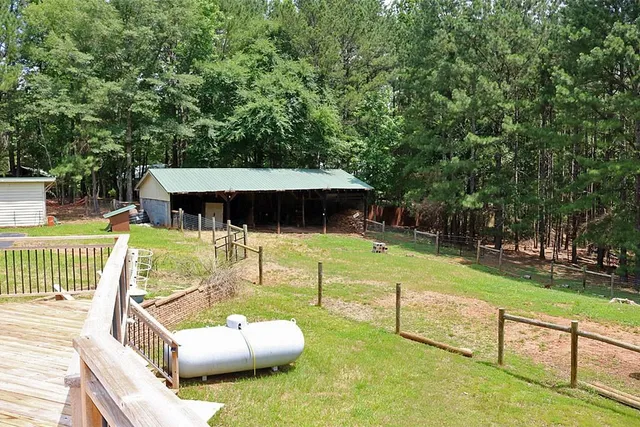 a view of a swimming pool with a bench and trees