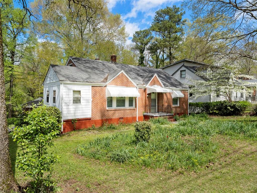 2614 Joyce Avenue Decatur, GA 30032 - Photo 1 of 1 a front view of a house with a yard table and chairs