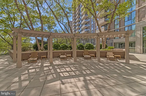 a dining hall with stainless steel appliances granite countertop a table and chairs in it