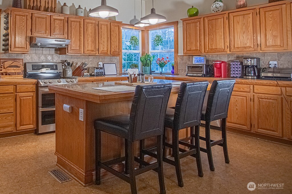 951 Bulman Road Southeast Port Orchard, WA 98366 - Photo 7 of 39 a kitchen with stainless steel appliances granite countertop a table chairs sink and cabinets