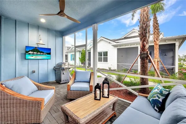 a living room with furniture a flat screen tv and a floor to ceiling window