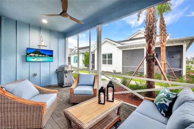 a living room with furniture a flat screen tv and a floor to ceiling window