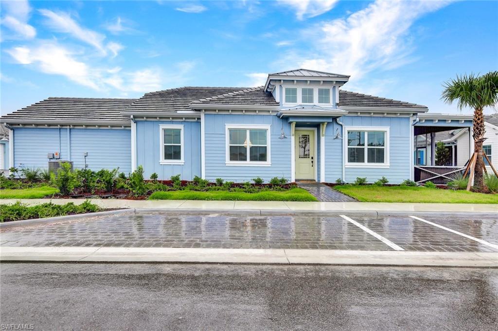 7142 Cayo Coco Lane Naples, FL 34113 - Photo 16 of 17 a front view of a house with a garden and plants