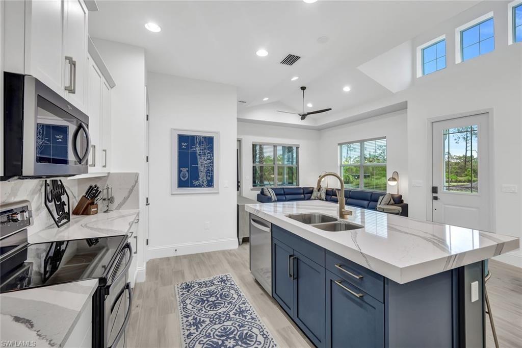 7142 Cayo Coco Lane Naples, FL 34113 - Photo 2 of 17 a kitchen with stainless steel appliances granite countertop a sink stove and refrigerator