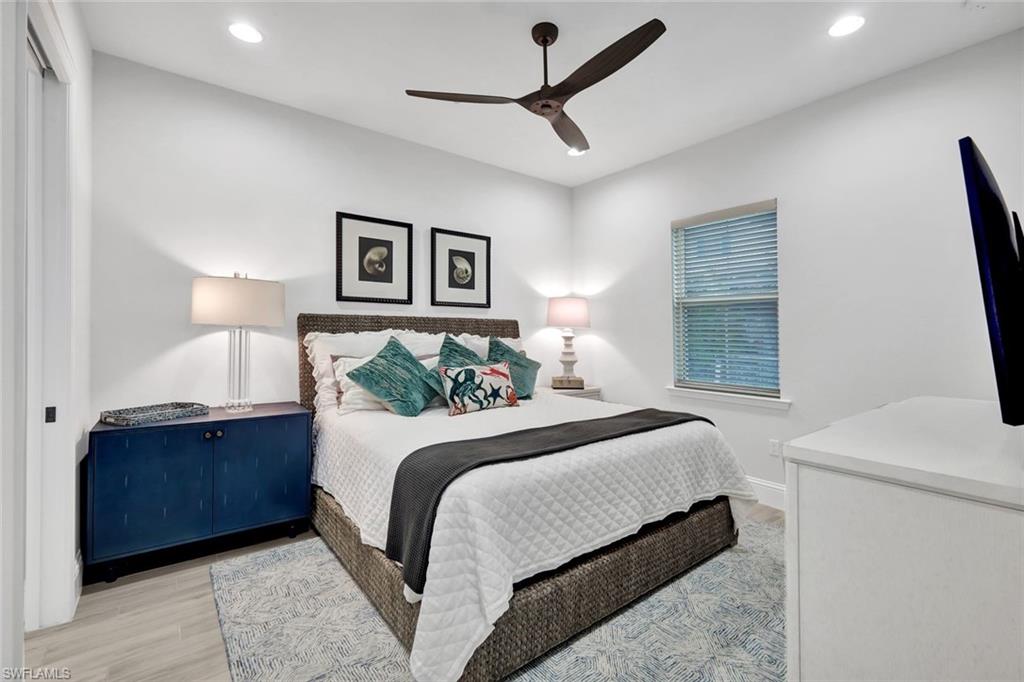 7142 Cayo Coco Lane Naples, FL 34113 - Photo 8 of 17 a bedroom with a large bed and a chandelier