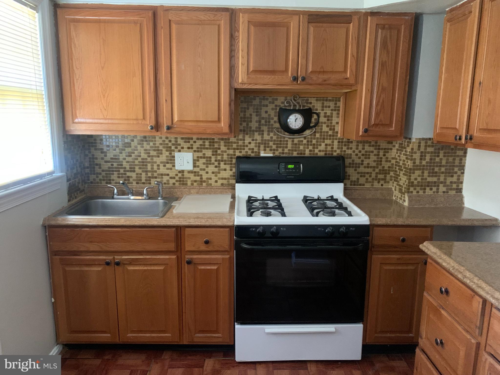1760 East W Highway Silver Spring, MD 20910 - Photo 2 of 21 a kitchen with granite countertop wood cabinets and a stove top oven