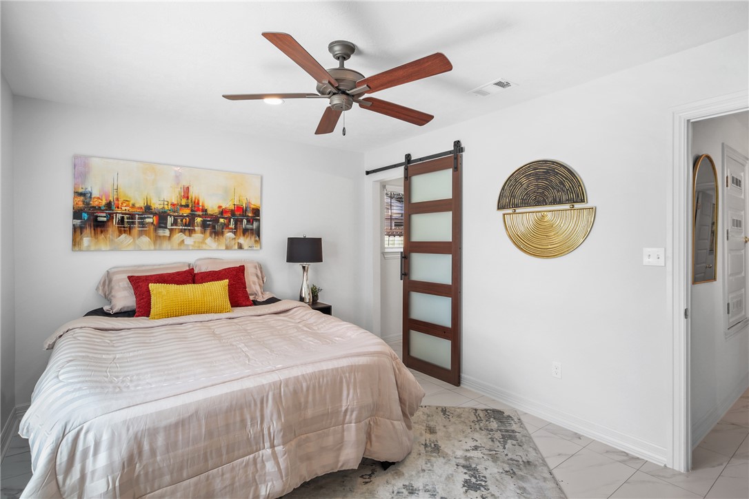 3004 Woodville Road Bryan, TX 77803 - Photo 18 of 26 a bedroom with a bed and a painting on the wall