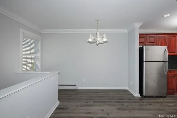 a view of a kitchen with a refrigerator and wooden floor