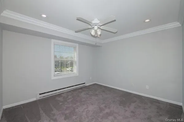an empty room with a window and ceiling fan