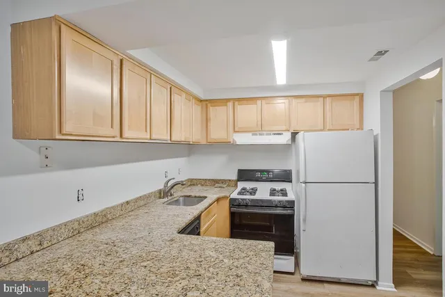 a kitchen with a refrigerator sink and cabinets