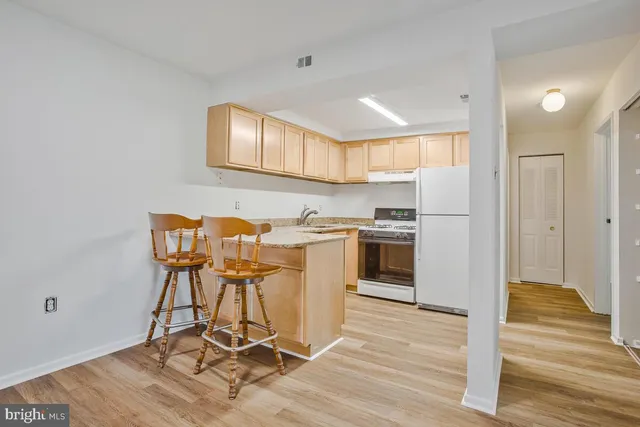 a kitchen with a table chairs refrigerator and cabinets