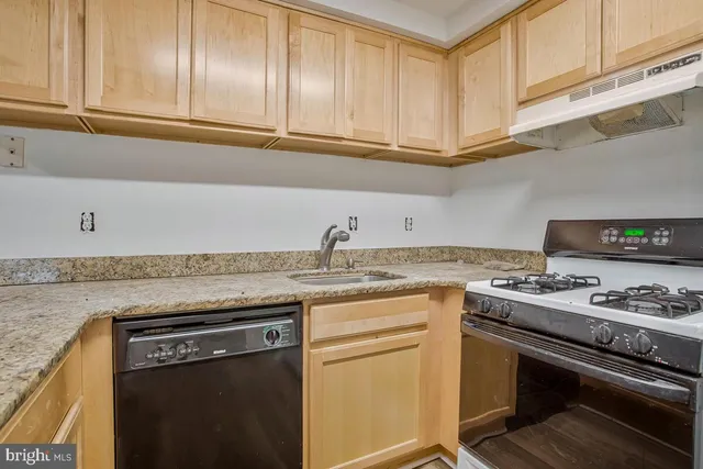 a kitchen with stainless steel appliances granite countertop a sink stove and cabinets