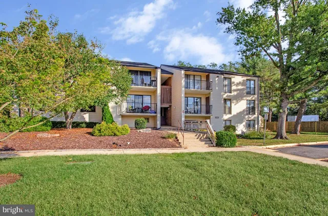 a front view of a house with a garden and tree