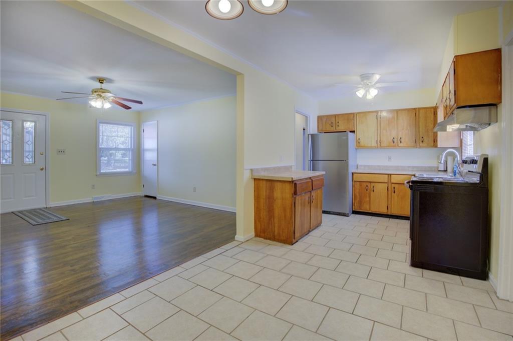 9174 Flat Shoals Road Southwest Covington, GA 30014 - Photo 12 of 25 a kitchen with stainless steel appliances a refrigerator a stove a sink and a microwave