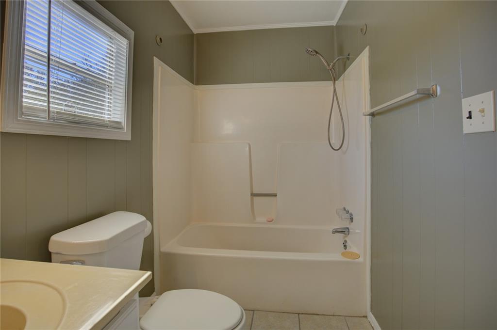 9174 Flat Shoals Road Southwest Covington, GA 30014 - Photo 18 of 25 a bathroom with a toilet and a bathtub