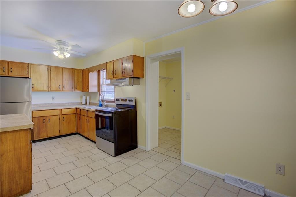 9174 Flat Shoals Road Southwest Covington, GA 30014 - Photo 9 of 25 a kitchen with stainless steel appliances granite countertop a stove a sink and a refrigerator