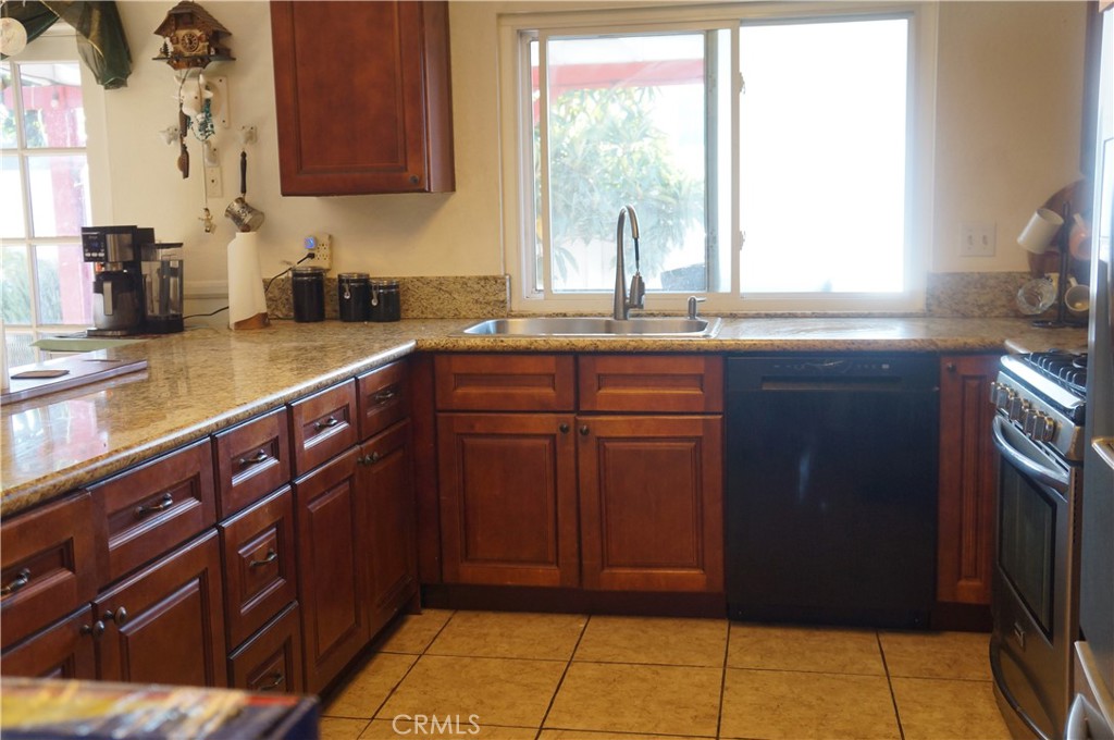 9442 Placer Street Rancho Cucamonga, CA 91730 - Photo 14 of 40 a kitchen with stainless steel appliances granite countertop wooden cabinets a sink and a window