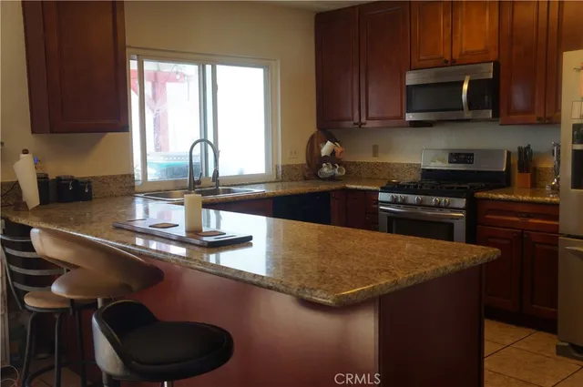 a kitchen with granite countertop a sink a stove and cabinets