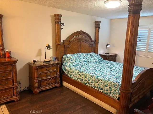 a bedroom with a bed and a mirror on the dresser