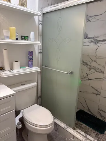 a bathroom with a toilet and a shower