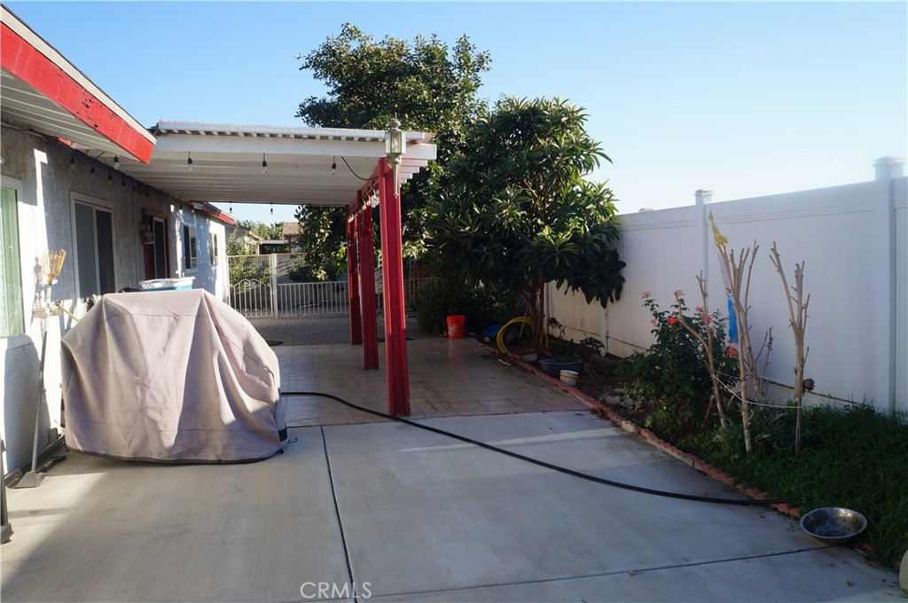 9442 Placer Street Rancho Cucamonga, CA 91730 - Photo 35 of 40 a view of a patio with table and chairs potted plants with wooden fence