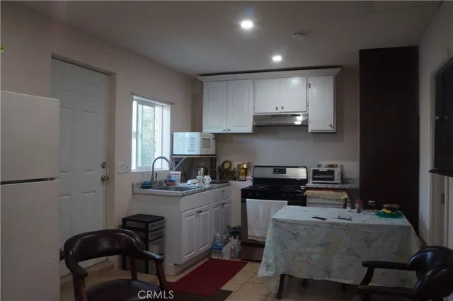 a kitchen with granite countertop a sink stove and cabinets