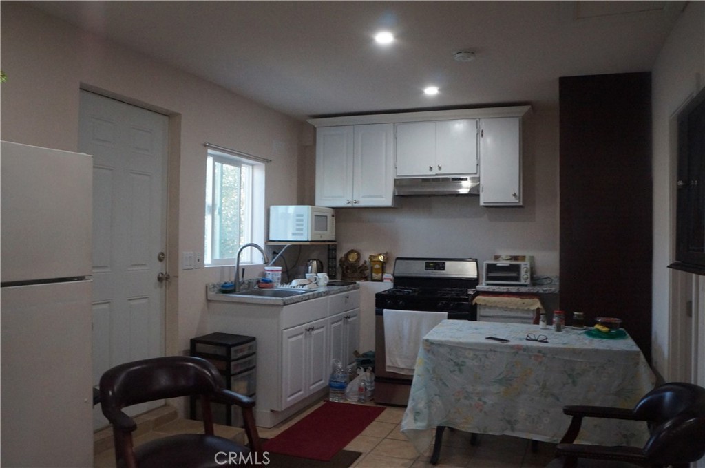 9442 Placer Street Rancho Cucamonga, CA 91730 - Photo 36 of 40 a kitchen with granite countertop a sink stove and cabinets