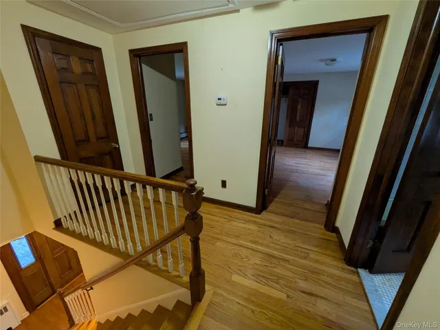 a view of a hallway with wooden floor and stairs