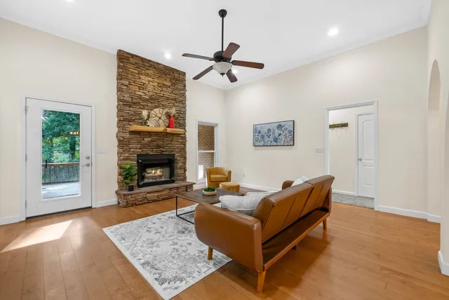 a living room with furniture a fireplace and a large window