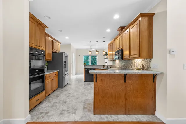 a kitchen with stainless steel appliances granite countertop a sink a stove a microwave and cabinets