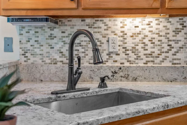 a kitchen with stainless steel appliances granite countertop a sink a stove and a refrigerator