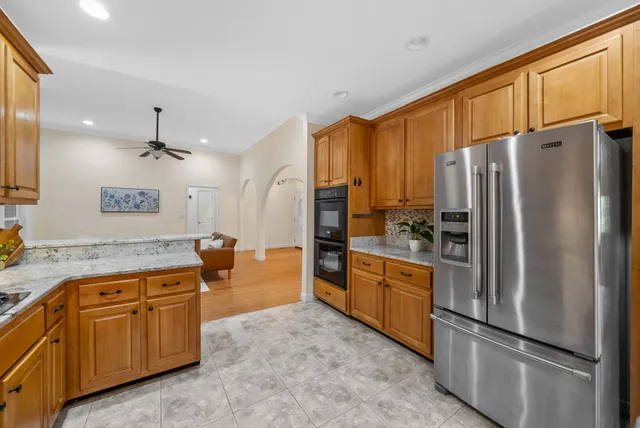 an empty room with windows and ceiling fan