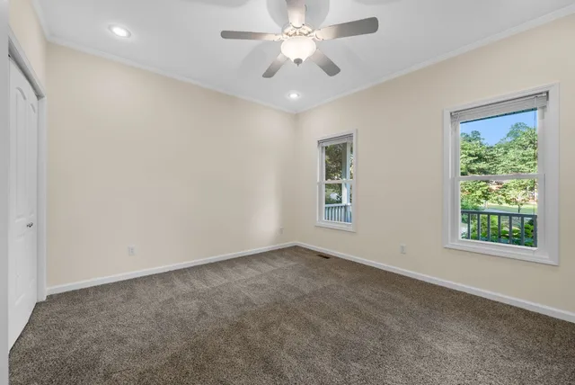 an empty room with a window and a ceiling fan