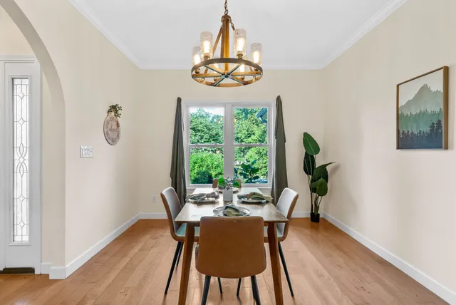 a view of a dining room with furniture a chandelier and wooden floor