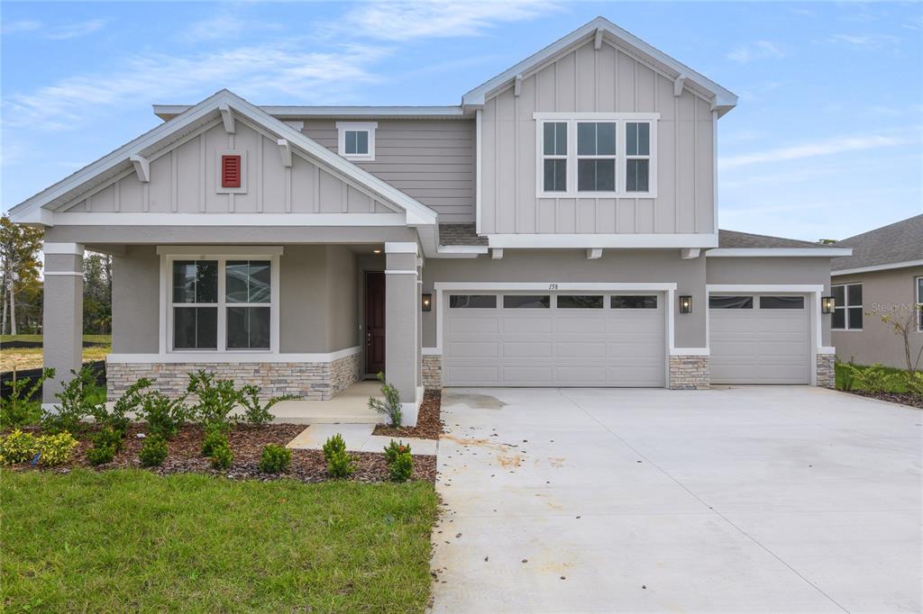 158 Waterstone Loop Tavares, FL 32778 - Photo 2 of 20 a front view of a house with a yard and garage