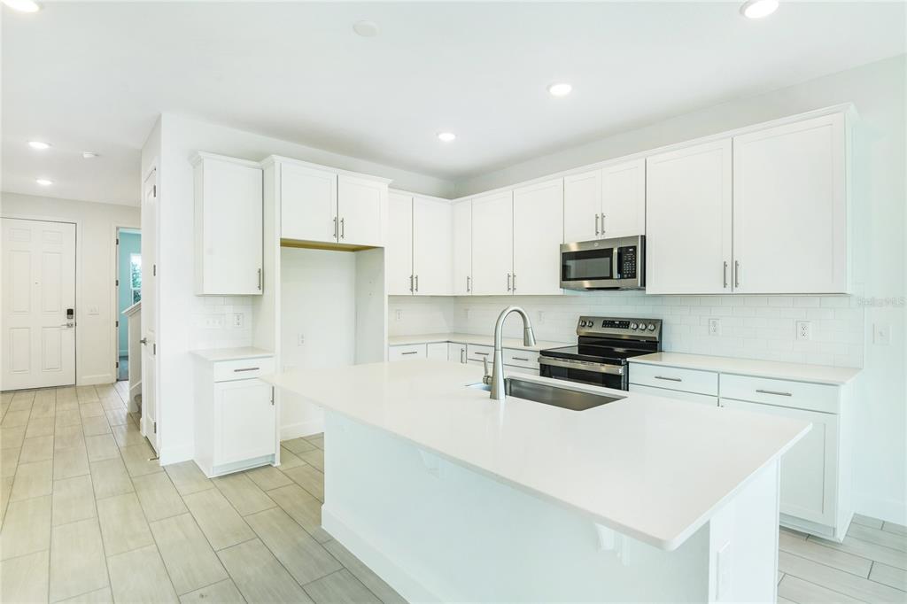 158 Waterstone Loop Tavares, FL 32778 - Photo 3 of 20 a kitchen with white cabinets and stainless steel appliances