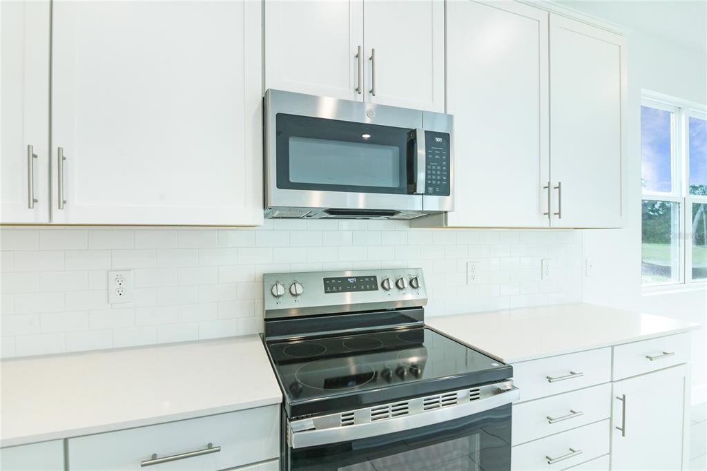 158 Waterstone Loop Tavares, FL 32778 - Photo 4 of 20 a kitchen with white cabinets and appliances
