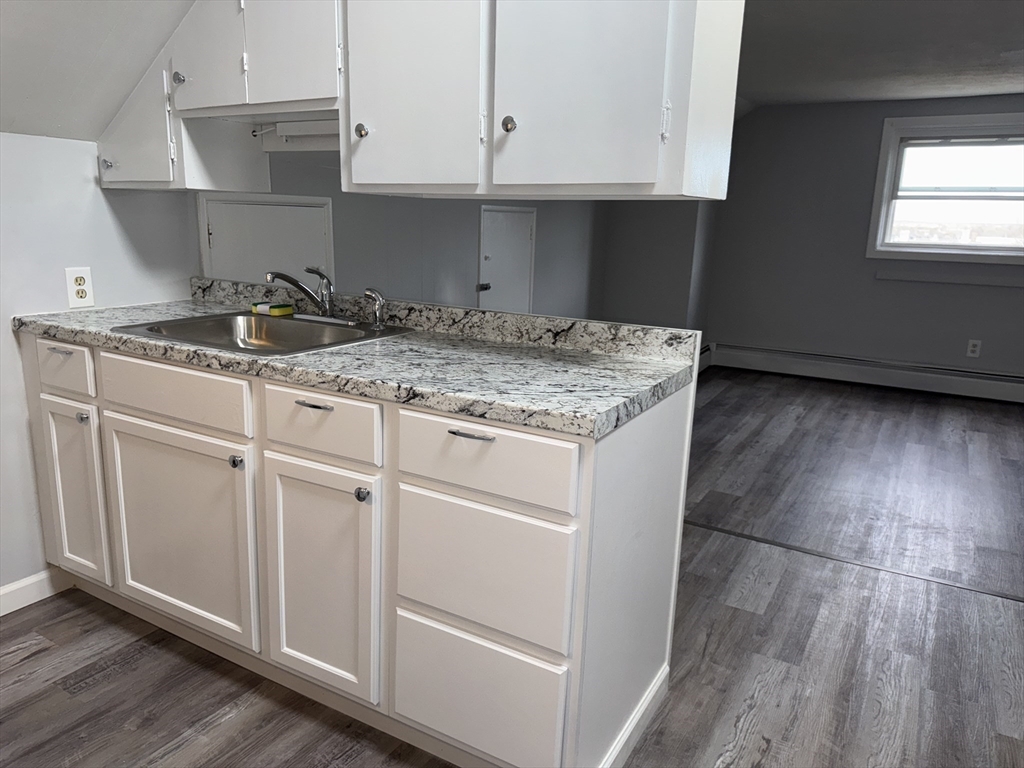 148 Maxfield Street, Unit 3 New Bedford, MA 02740 - Photo 9 of 21 a kitchen with cabinets appliances and a wooden floor