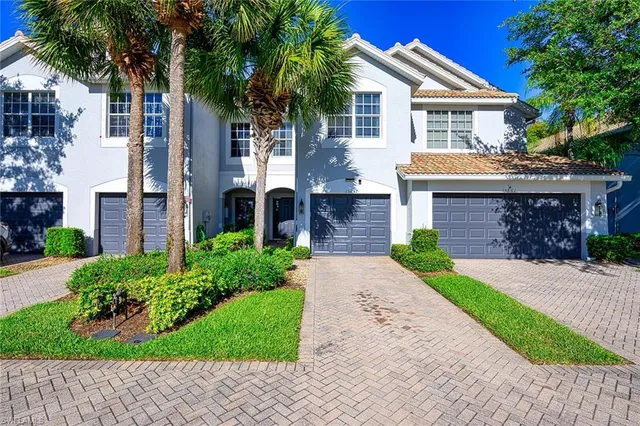 a front view of a house with a garden and trees