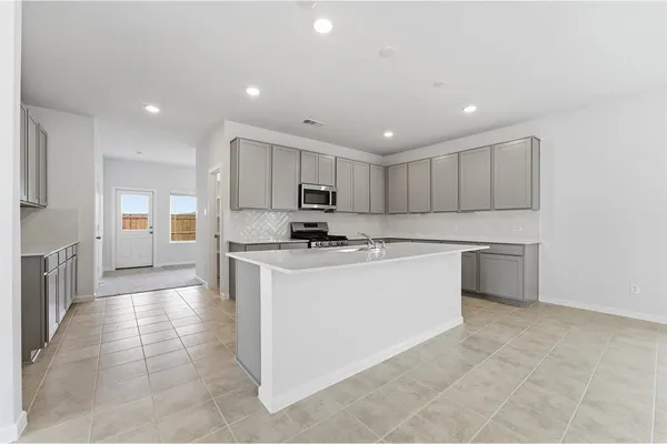 a kitchen with a refrigerator and a stove top oven