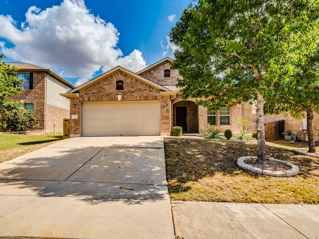 225 Razzmatazz Trail Buda, TX 78610 - Photo 1 of 28 a front view of a house with garden and patio